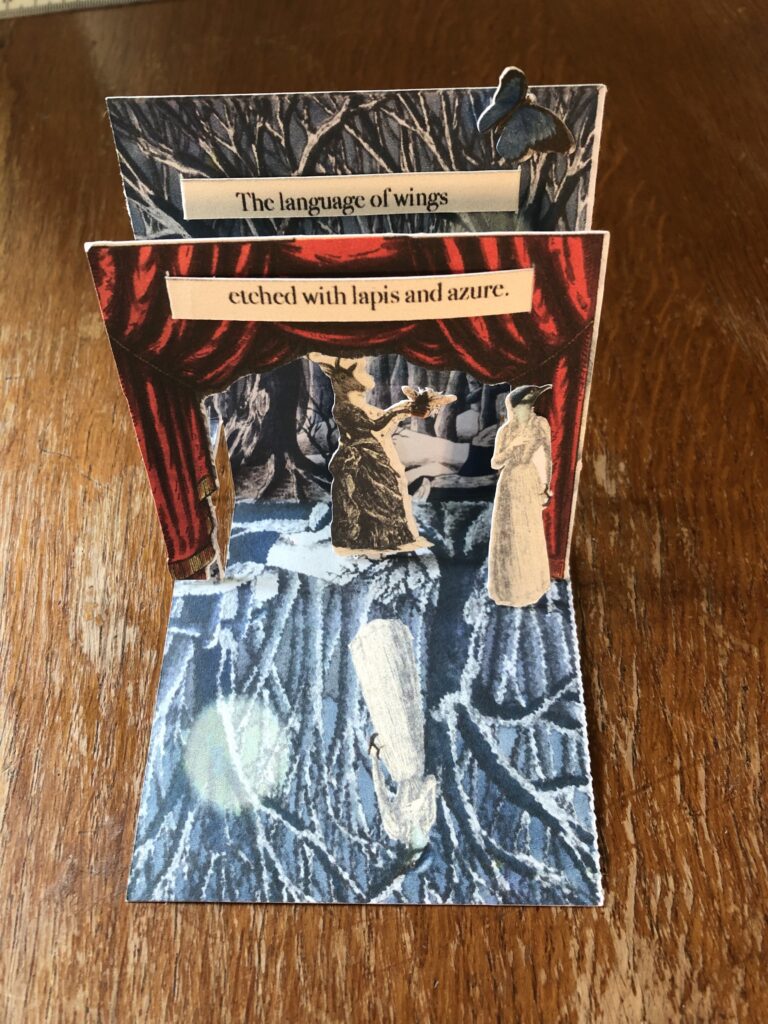 Image of a pop-up card that shows blue trees and moon on the background and foreground layer, with theatre curtains popping out framing a deer-headed character in female dress. Text overlaid reads 'the language of wings etched with lapis and azure'. This might be one technique to use in a visual poetry book
